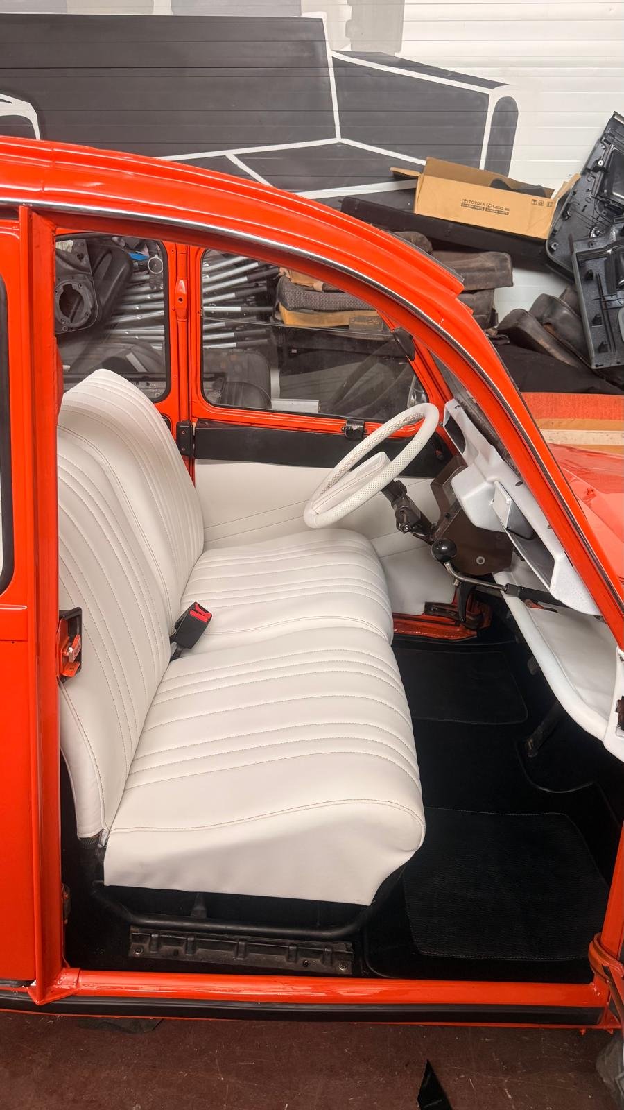 Foto exterior de vehículo naranja con tapizado blanco